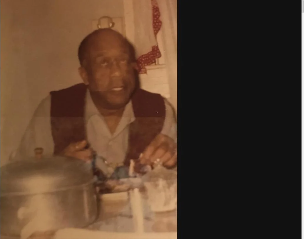 A warm archival photograph of a family elder seated at the table for a celebration meal