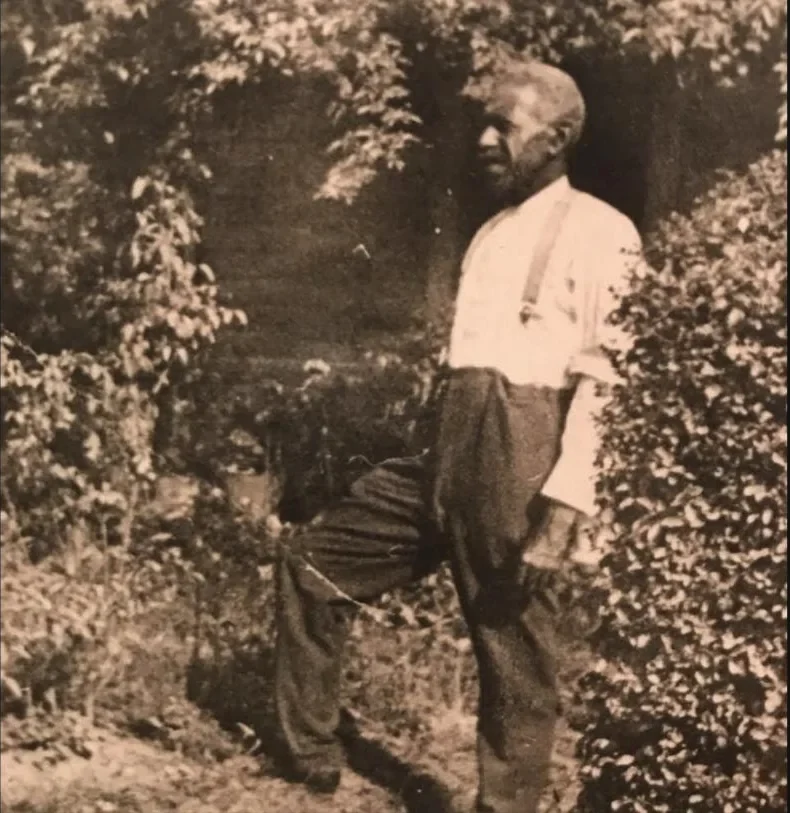 A sepia photograph of Rev. John Wesley Neill standing in a garden