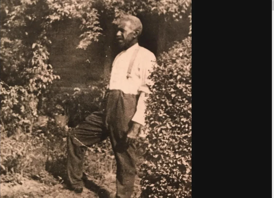 A sepia photograph of Rev. John Wesley Neill standing in a garden