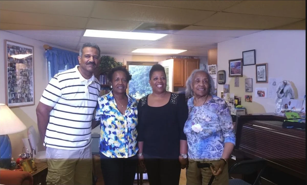Four family members smiling together during a family visit