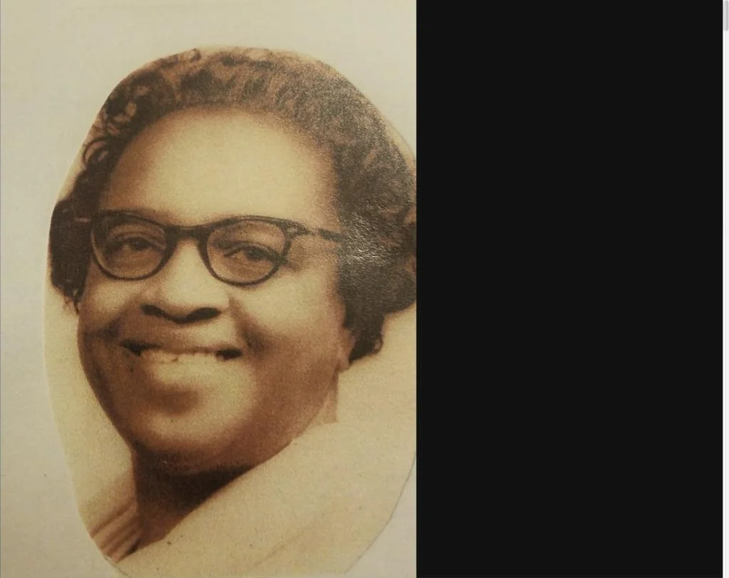 A sepia portrait of Harriet Neill Warren wearing glasses and smiling warmly