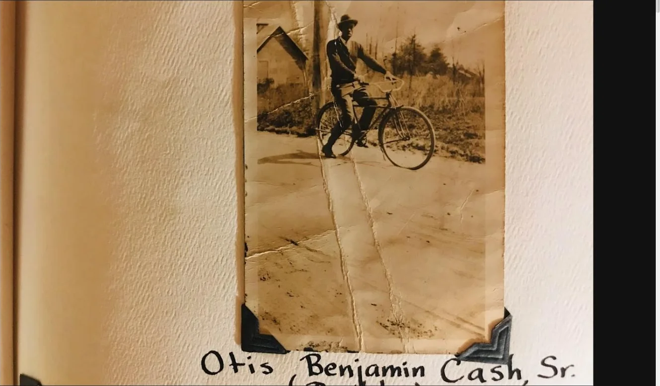 A family album page showing Otis Benjamin Cash, Sr. beside his bicycle with his name handwritten below